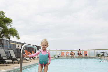 Porträt eines Mädchens, das am Pool vor einem bewölkten Himmel steht - CAVF43124