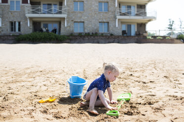 Mädchen spielt mit Spielzeug am Sandstrand an einem sonnigen Tag - CAVF43126