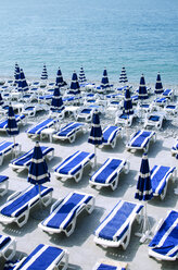 High angle view of deck chairs with parasols arranged at beach during sunny day - CAVF43168
