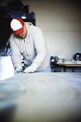 Handwerker prüft die Qualität des Holzes in der Werkstatt - CAVF43194