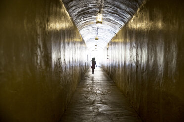 Rear view of silhouette girl running at passage - CAVF43209