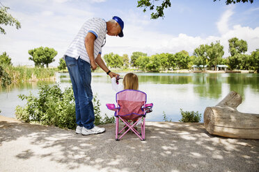 Grandfather and granddaughter fishing at lakeshore - CAVF43215