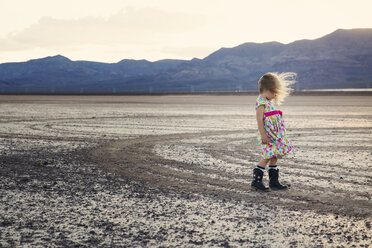 Seitenansicht eines Mädchens, das in einer trockenen Landschaft steht - CAVF43237
