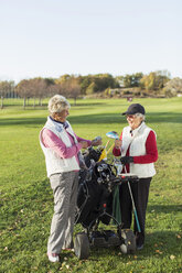 Lächelnde ältere Frau mit Golftasche auf dem Golfplatz in voller Länge - MASF05650