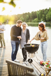 Friends enjoying barbecue party on pier - MASF05665