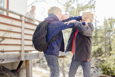 Brothers fighting while mother looking at them from balcony - MASF05701