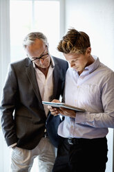 Geschäftsleute benutzen ein digitales Tablet im Büro - MASF05760