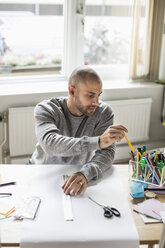 Geschäftsmann arbeitet am Schreibtisch in einem kreativen Büro - MASF05782