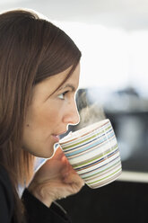 Businesswoman having coffee in office - MASF05787