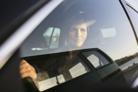 Geschäftsfrau schaut beim Autofahren durch das Fenster, lizenzfreies Stockfoto