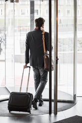 Businessman with luggage leaving hotel - MASF05820