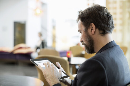 Geschäftsmann mit digitalem Tablet im Hotelrestaurant - MASF05821