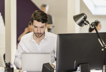 Geschäftsmann mit Laptop am Schreibtisch im Büro - MASF05831