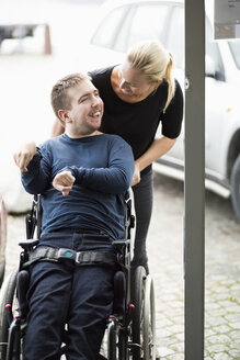 Hausmeister im Gespräch mit einem behinderten Mann im Rollstuhl im Freien - MASF05863