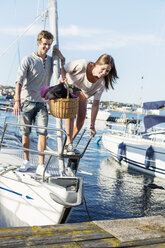 Junges Paar steigt aus einem Segelboot aus - MASF05914