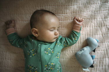 Overhead view of baby girl sleeping on bed at home - CAVF43487