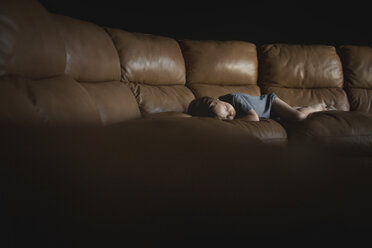 Schlafender Junge auf dem Sofa in der Dunkelkammer zu Hause - CAVF43497