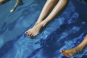 Frauenbeine baumeln im Schwimmbad - CAVF43530
