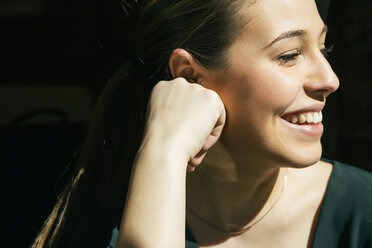 Close-up Seitenansicht einer lächelnden Frau, die sich an einem sonnigen Tag ausruht - CAVF43532