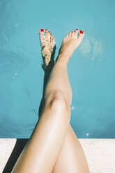 Erste Person-Ansicht der Beine und Füße einer Frau am Pool - CAVF43535