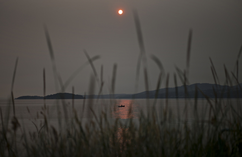 Blick auf den See mit Sonnenspiegelung, lizenzfreies Stockfoto