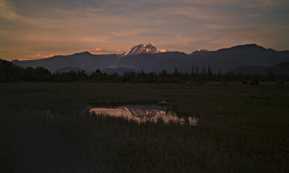 Berg, der sich im Winter bei Sonnenuntergang in einer Pfütze spiegelt - CAVF43566