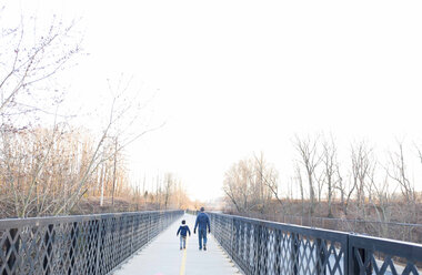 Rückansicht von Vater und Sohn auf der Brücke gegen den klaren Himmel - CAVF43633