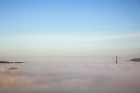 Majestätischer Blick auf die Wolken, die die Golden Gate Bridge vor blauem Himmel verdecken - CAVF43652