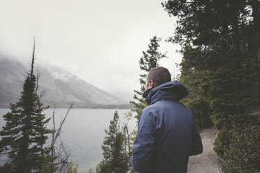 Man in warm clothing looking at view while standing at Grand Teton National Park - CAVF43765