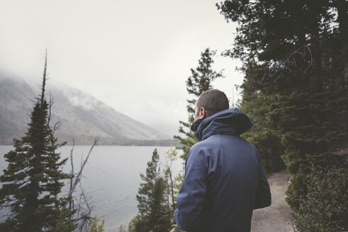 Mann in warmer Kleidung betrachtet die Aussicht im Grand Teton National Park - CAVF43765
