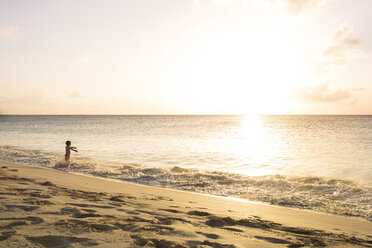 Junge spielt am Strand gegen den Himmel an einem sonnigen Tag - CAVF43790