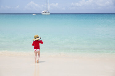 Rückansicht eines Mädchens, das sich am Strand an einem sonnigen Tag vergnügt - CAVF43824