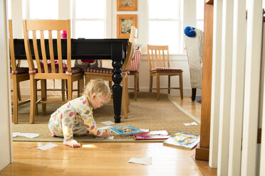 Side view of girl coloring while sitting in living room at home - CAVF43840