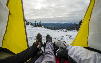 Niedriger Ausschnitt von Freunden, die sich im Zelt auf einem schneebedeckten Berg ausruhen - CAVF43848