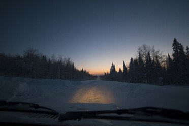 Schneebedecktes Feld gegen klaren Himmel durch die Windschutzscheibe eines Autos gesehen - CAVF43852