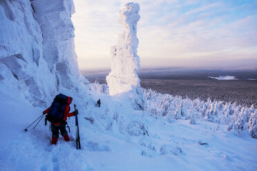 Friends hiking on snow covered landscape against cloudy sky - CAVF43860