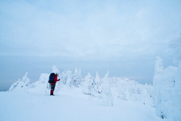 Seitenansicht von Wanderer stehend auf schneebedeckten füllen gegen bewölkten Himmel - CAVF43861