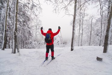 Rückansicht eines Mannes beim Skifahren auf einem schneebedeckten Feld - CAVF43866