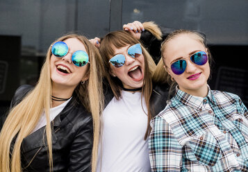 Porträt von glücklichen Freundinnen mit Sonnenbrille in der Stadt - CAVF43878