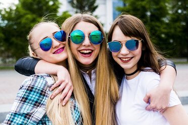 Porträt von glücklichen Freundinnen mit Sonnenbrillen auf dem Fußweg stehend - CAVF43879