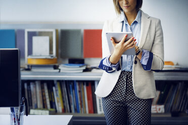 Midsection von Geschäftsfrau mit Tablet-Computer im Büro - CAVF43893