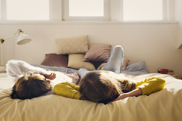 Sisters relaxing on bed at home - CAVF43937