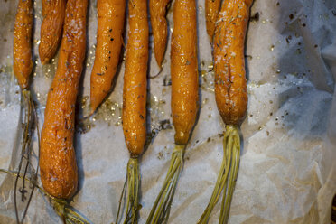 Overhead view of roasted carrots on tissue paper - CAVF44001