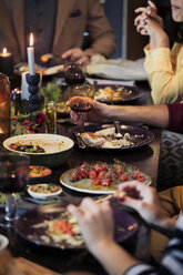 Friends enjoying meal at table during Christmas - CAVF44007