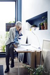 Frau telefoniert bei der Arbeit im Büro - CAVF44073