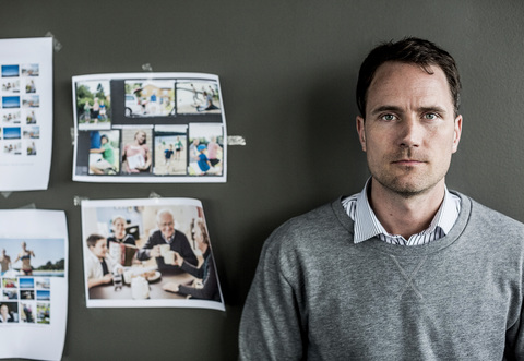 Porträt eines seriösen Geschäftsmannes, der in einem Büro an der Wand steht, lizenzfreies Stockfoto