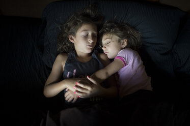 Hohe Winkel Ansicht der Schwestern schlafen auf Bett zu Hause - CAVF44163