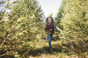 Portrait of happy girl running on field at park - CAVF44173