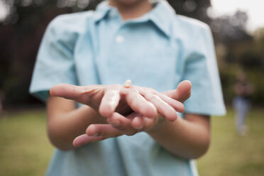 Boy holding small stone on hand - CAVF44223