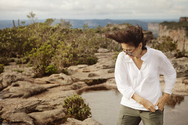 Senior woman exploring lake in mountains - CAVF44268